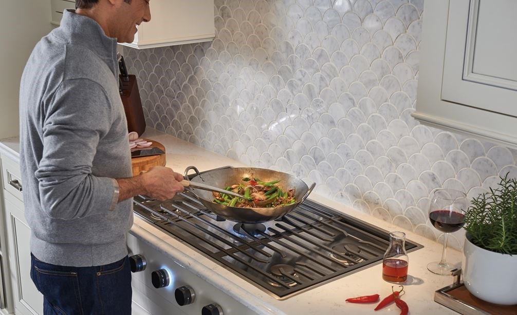 La placa de cocción de gas contemporánea de 36" Wolf de 5 quemadores (CG365C/S) muestra que cocinar es una delicia en este diseño de cocina de textura blanca limpia