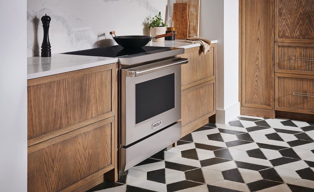 Wolf 36&quot; Professional Induction Range featured in textured modern kitchen design with black and white tile flooring.