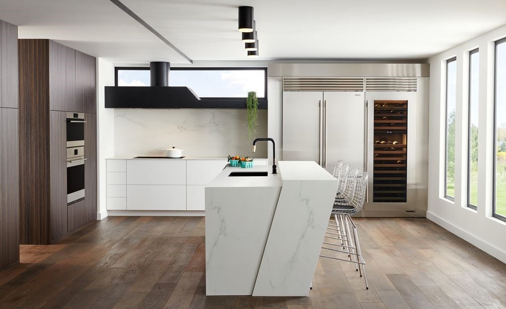 Refrigerador congelador de 48" con puertas francesas de la serie Classic en acero inoxidable se integra a la perfección en este diseño de cocina moderna y elegante de estilo europeo, con una gran isla de mármol blanco.