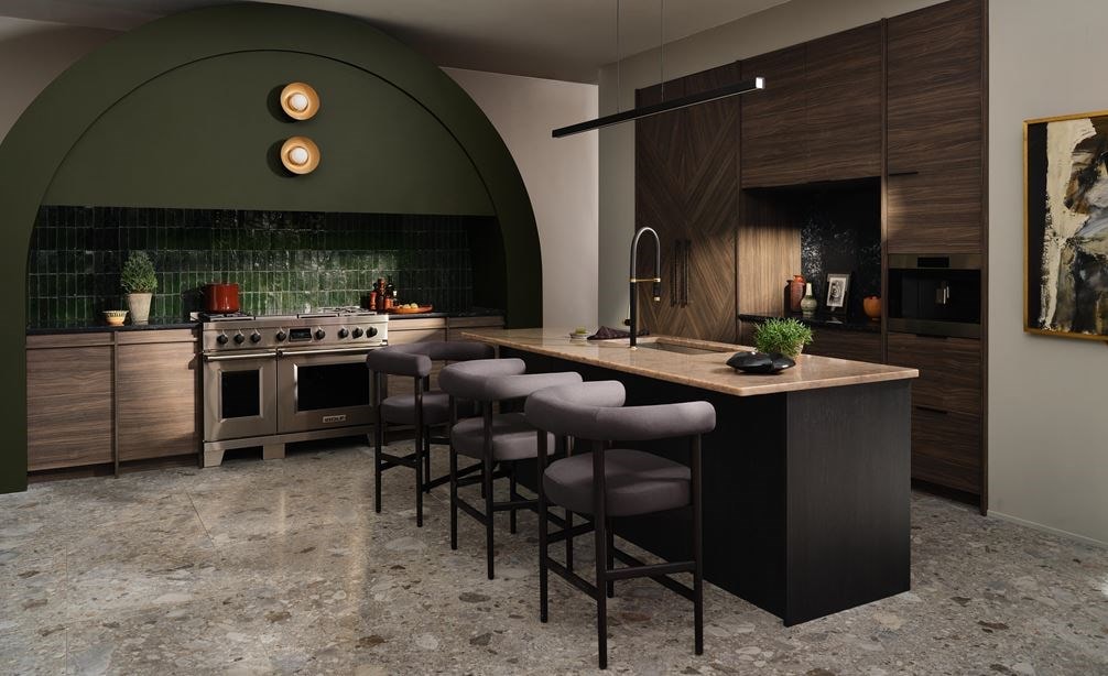 Sistema de café Wolf Transitional de la serie E de 24", instalado en el centro de una gran cocina con arcos en tono verde bosque, con salpicadero personalizado en verde “racing” y carpintería de madera sin tiradores