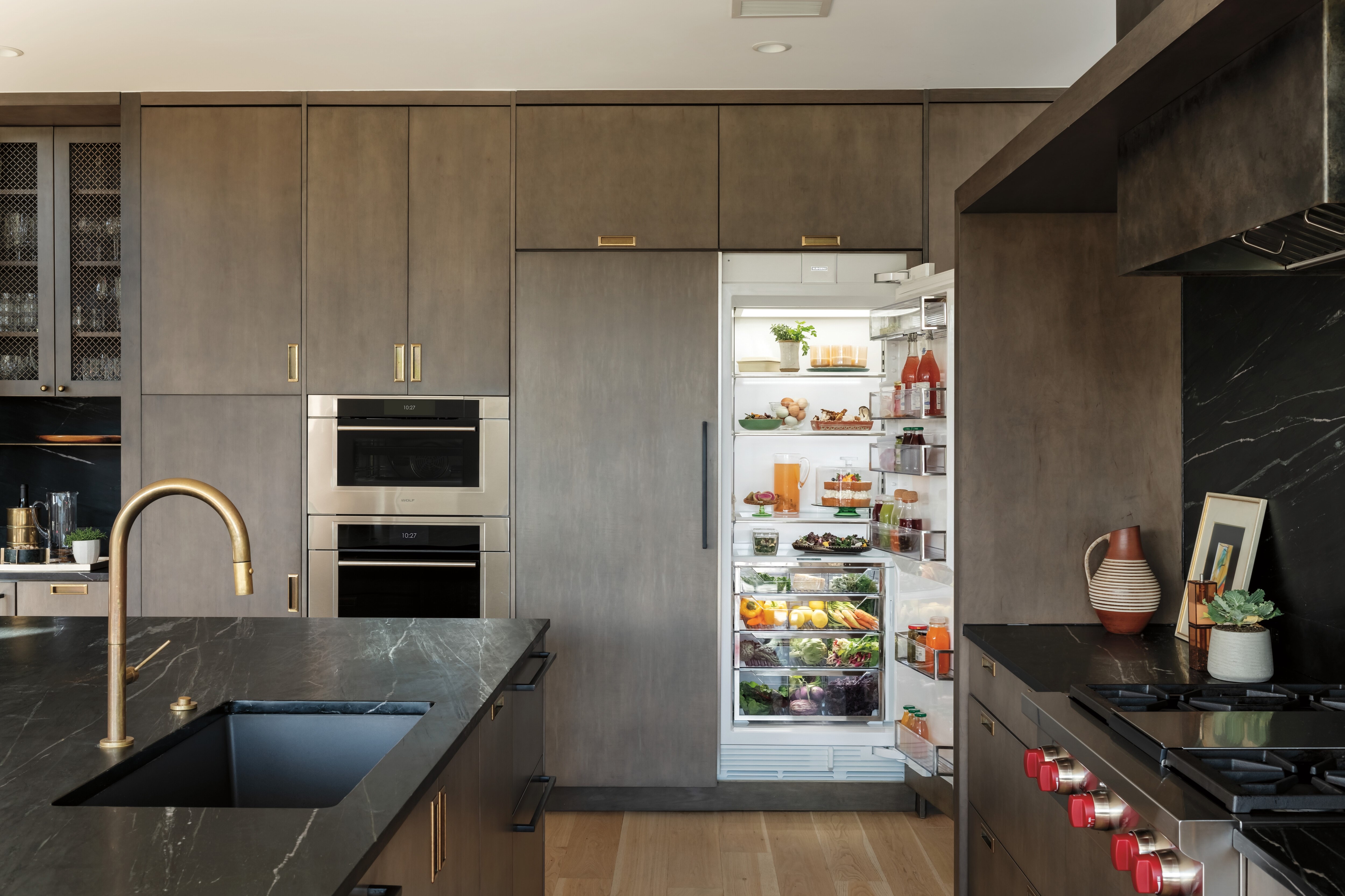 Refrigerador de columna Sub-Zero de 30" con puertas integrables con dispensador interno y congelador de columna con fabricador de hielo, integradas a la perfección en una cocina contemporánea sofisticada y minimalista.