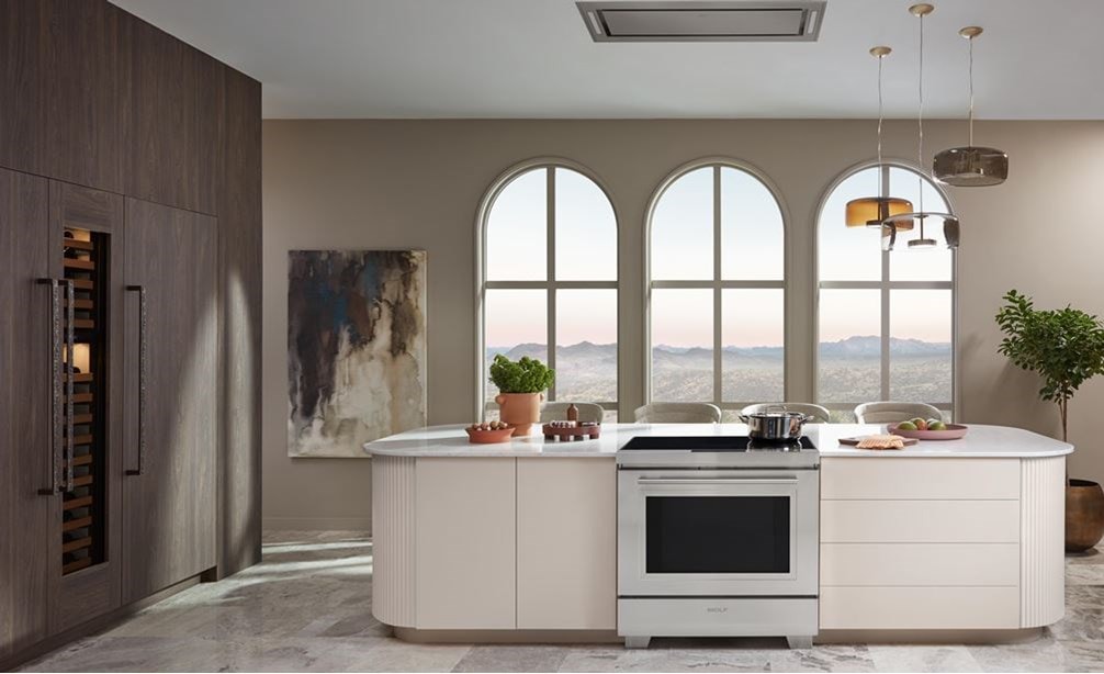 Wolf 30&quot; Induction Range shown centered in front of arch windows in sleek custom kitchen island with pendant light above. 