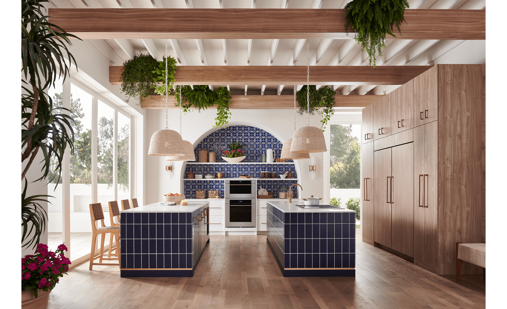 Horno de vapor con convección Wolf Transitional de la serie M de 30", exhibido en una cocina mediterránea con doble isla, salpicadero de azulejos azules personalizados y techo con vigas de madera expuestas 