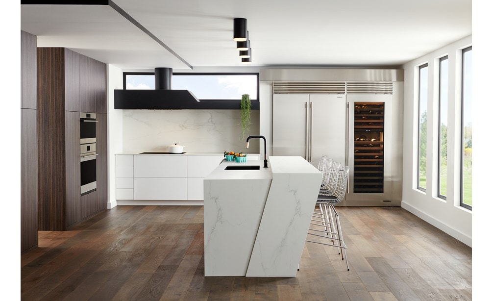 Refrigerador congelador de 48" con puertas francesas de la serie Classic en acero inoxidable se integra a la perfección en este diseño de cocina moderna y elegante de estilo europeo, con una gran isla de mármol blanco.