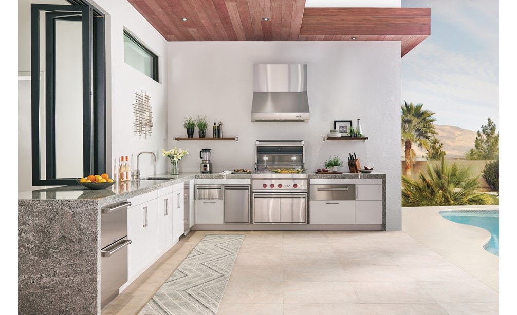 Diseño de cocina exterior personalizado con cajón refrigerador exterior Sub-Zero, asador de gas exterior Wolf de 4 quemadores y lavavajillas exterior Cove