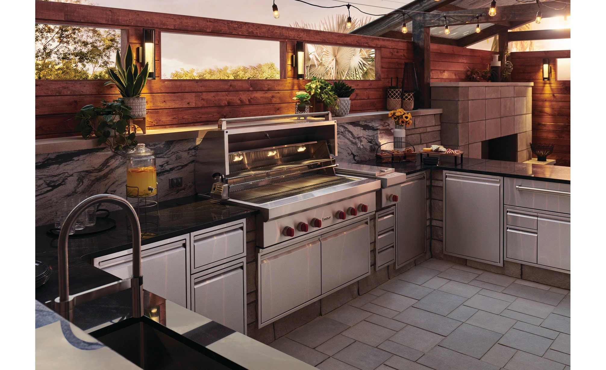 La parrilla de gas para exteriores de 54” Wolf (OG54) se combina a la perfección con un elegante diseño moderno de cocina para exteriores que ofrece comodidades de calidad profesional.