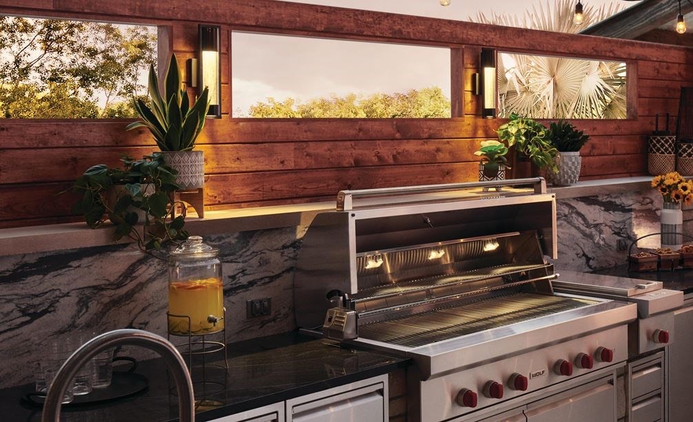 La parrilla de gas para exteriores de 54” Wolf (OG54) se combina a la perfección con un elegante diseño moderno de cocina para exteriores que ofrece comodidades de calidad profesional.