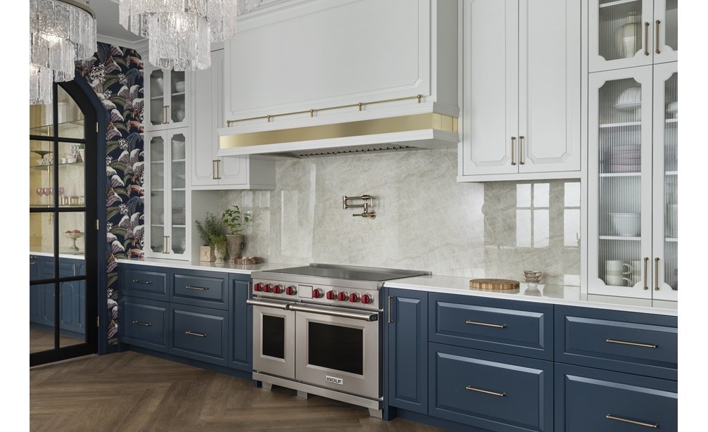 Wolf Professional Induction Range shown in an elegantly appointed modern kitchen featuring tall arched glass upper kitchen cabinets with dark slate blue lower cabinetry.