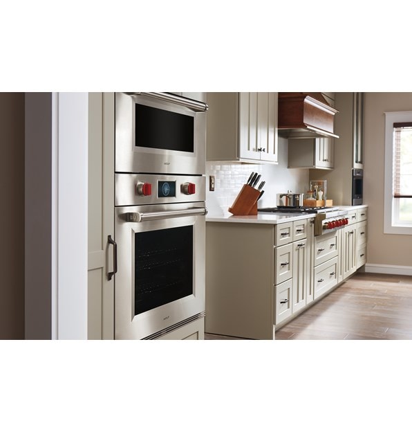 Congelador/refrigerador Designer bajo y sobre mostrador de 30" Sub-Zero con máquina de hacer hielo y dispensador interno compatible con paneles exhibido en un diseño de cocina moderno y elegante. 