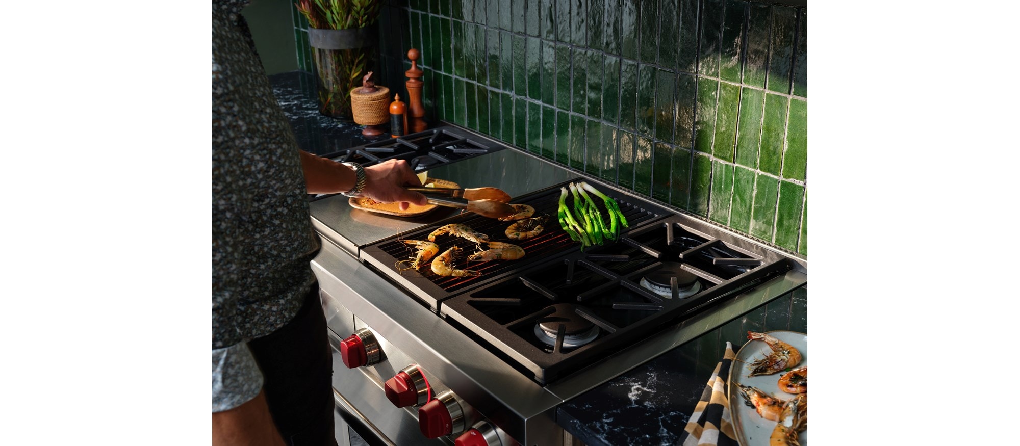 A man cooking a few pieces of food on his Wolf Range.