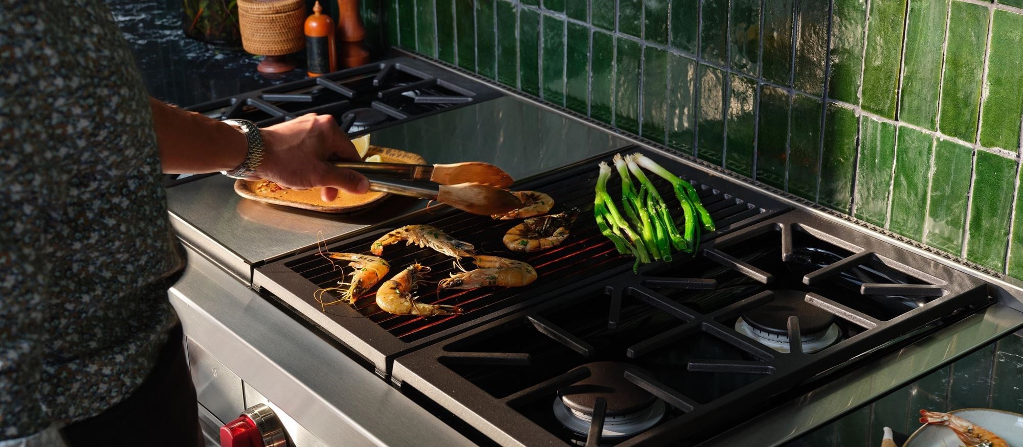 A man cooking a few pieces of food on his Wolf Range.