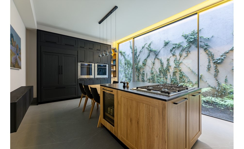 Luxury kitchen within the Sub-Zero, Wolf, and Cove showroom in Mexico City featuring black cabinets and a view outside.