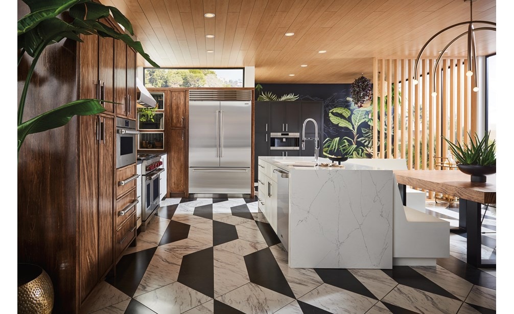 Refrigerador de la Serie Sub-Zero Classic integrado en gabinetes personalizados de madera teñida en una cocina iluminada por el sol y terrosa