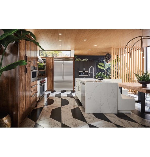 Refrigerador de la Serie Sub-Zero Classic integrado en gabinetes personalizados de madera teñida en una cocina iluminada por el sol y terrosa