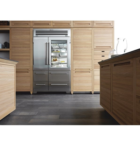 Refrigerador de acero inoxidable de la serie Pro Sub-Zero en una cocina con gabinetes de madera ligera