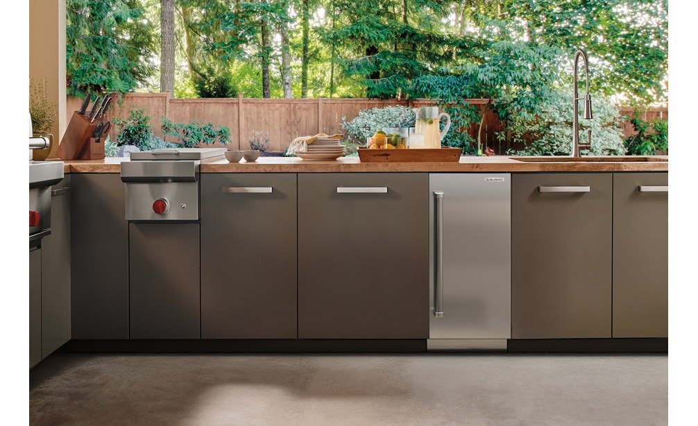 High end Sub-Zero 15" Indoor-Outdoor Clear Ice Maker discreetly integrated in sleek cabinetry of a luxury outdoor kitchen.