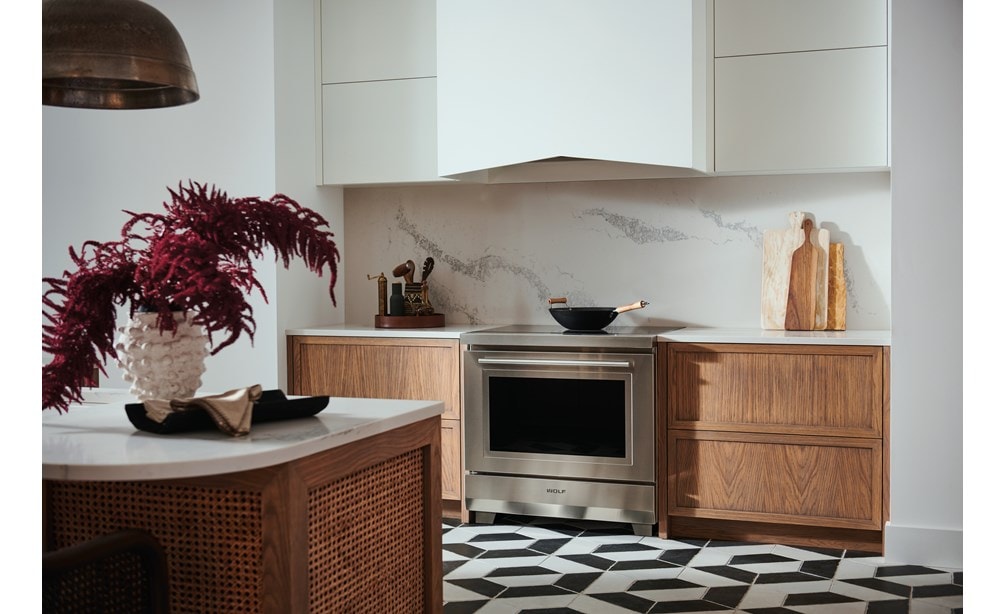 Estufa de inducción transicional de 36” Wolf (IR36550/S/T) exhibida con revestimiento de campana Pro de 40” Wolf (PL402212)