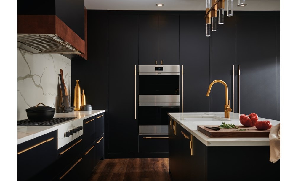 Wolf M Series Ovens and Wolf Contemporary Gas Cooktop shown in upscale luxury kitchen featuring seamless dark blue cabinetry