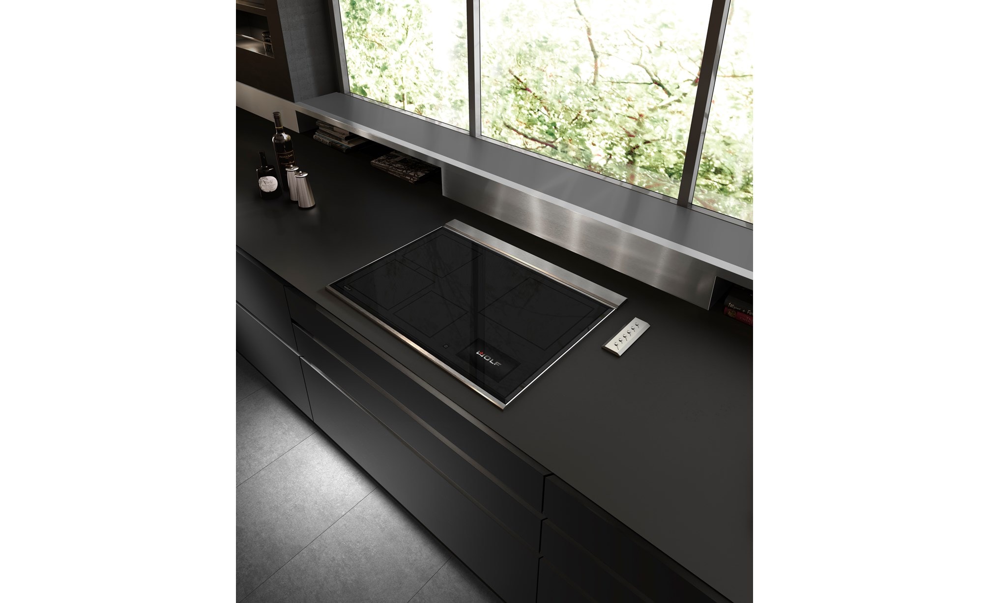 Placa de inducción transicional de 30" Wolf (CI30460T/S) exhibida en un elegante diseño de cocina ultramoderno con mostradores negros lisos, salpicadero de acero inoxidable y gabinetes sin manija 