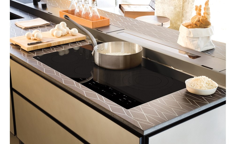 Placa de cocción eléctrica contemporánea de 36" Wolf (CE365C/B) instalada a ras en un espacio de cocina de lujo con mostrador de diseño y gabinetes con un acabado pulido