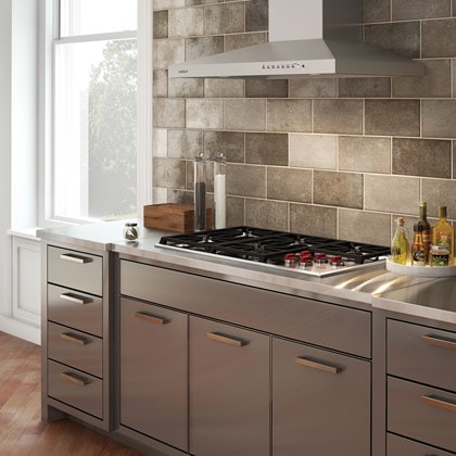 La placa de cocción de gas profesional de 36" Wolf (CG365P/S) y la campana extractora de pared de 36" Wolf - Inoxidable (VW36S) en un elegante diseño de cocina