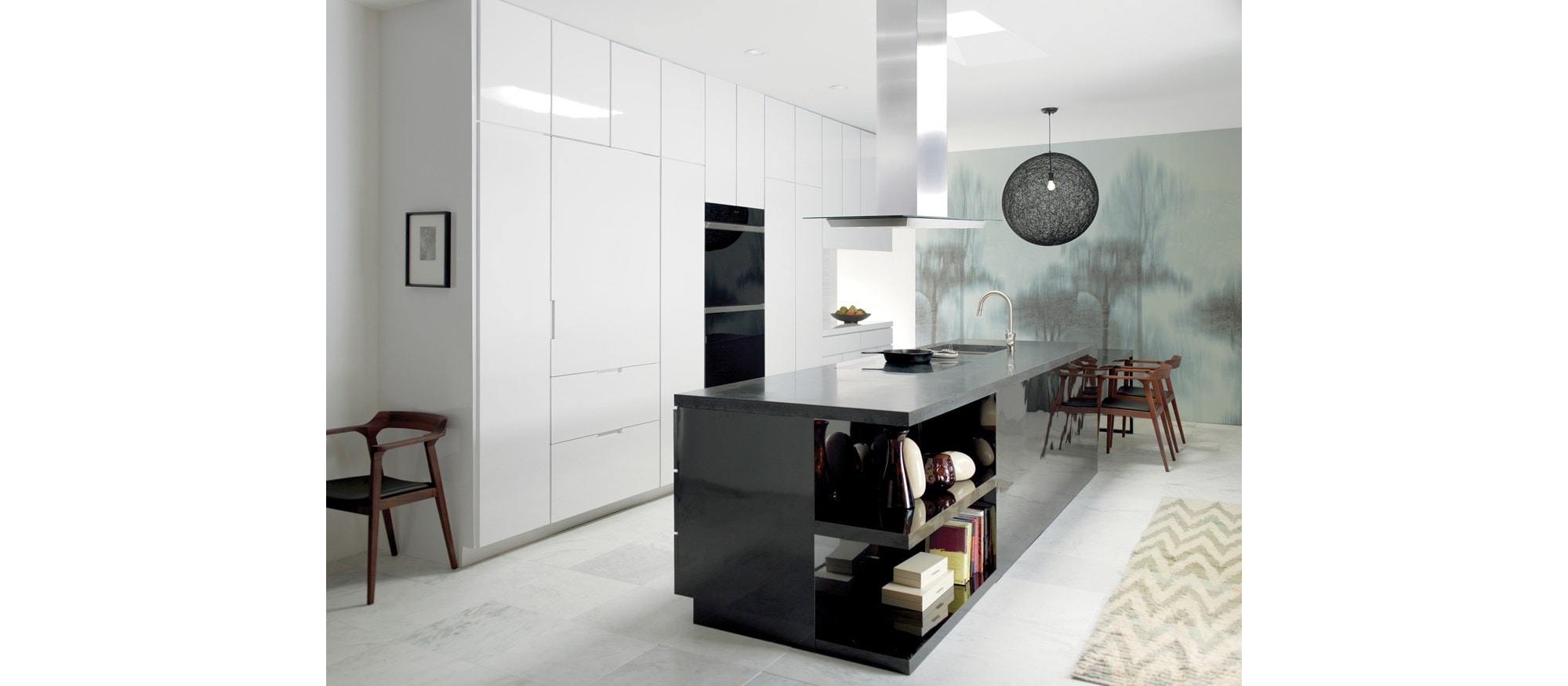 La placa de inducción contemporánea de 30" Wolf (CI304C/B) se presenta en una gran cocina abierta con isla de granito para comer