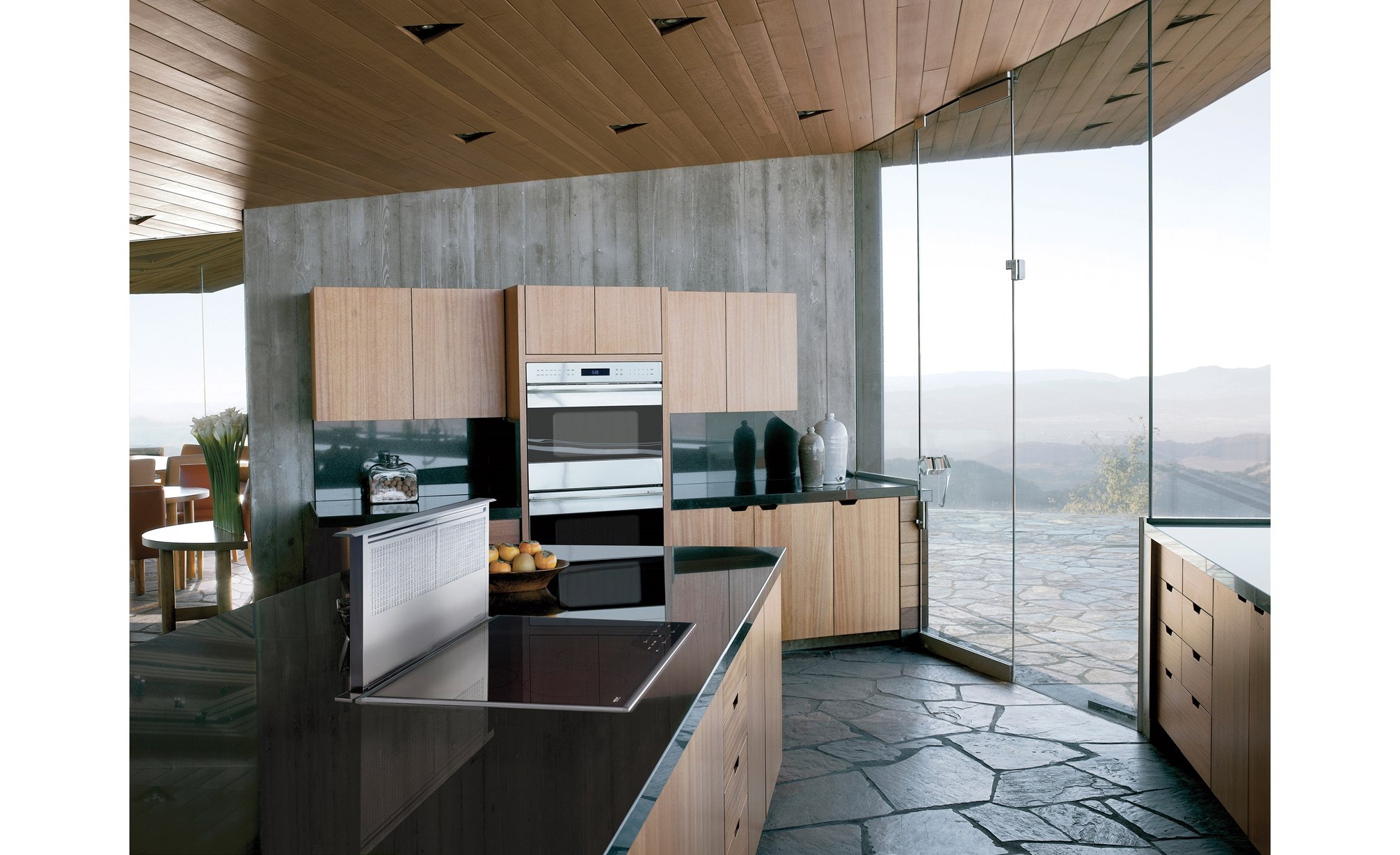 La placa de inducción transicional de 36" Wolf (CI365T/S) exhibida con ventilación de tiro descendente de 36" (DD36) en un gran mostrador de granito liso