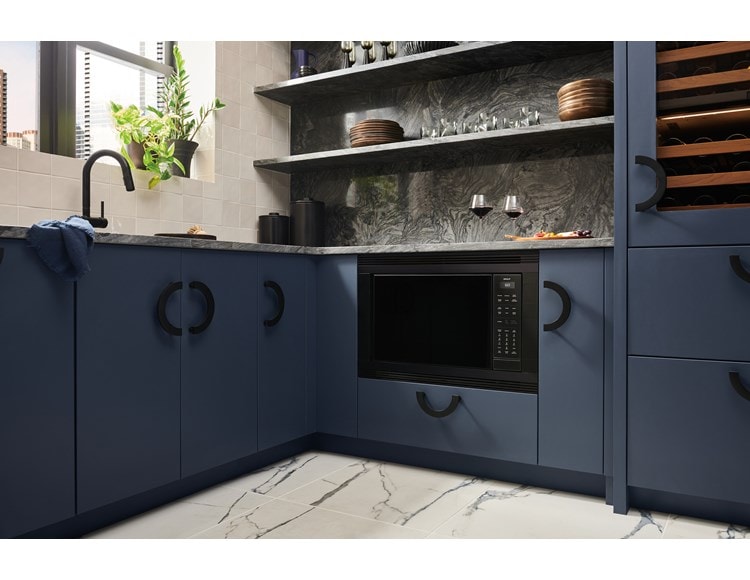 Wolf Standard Swing Microwave flushed with the cabinetry of a luxury, blue-colored kitchen.