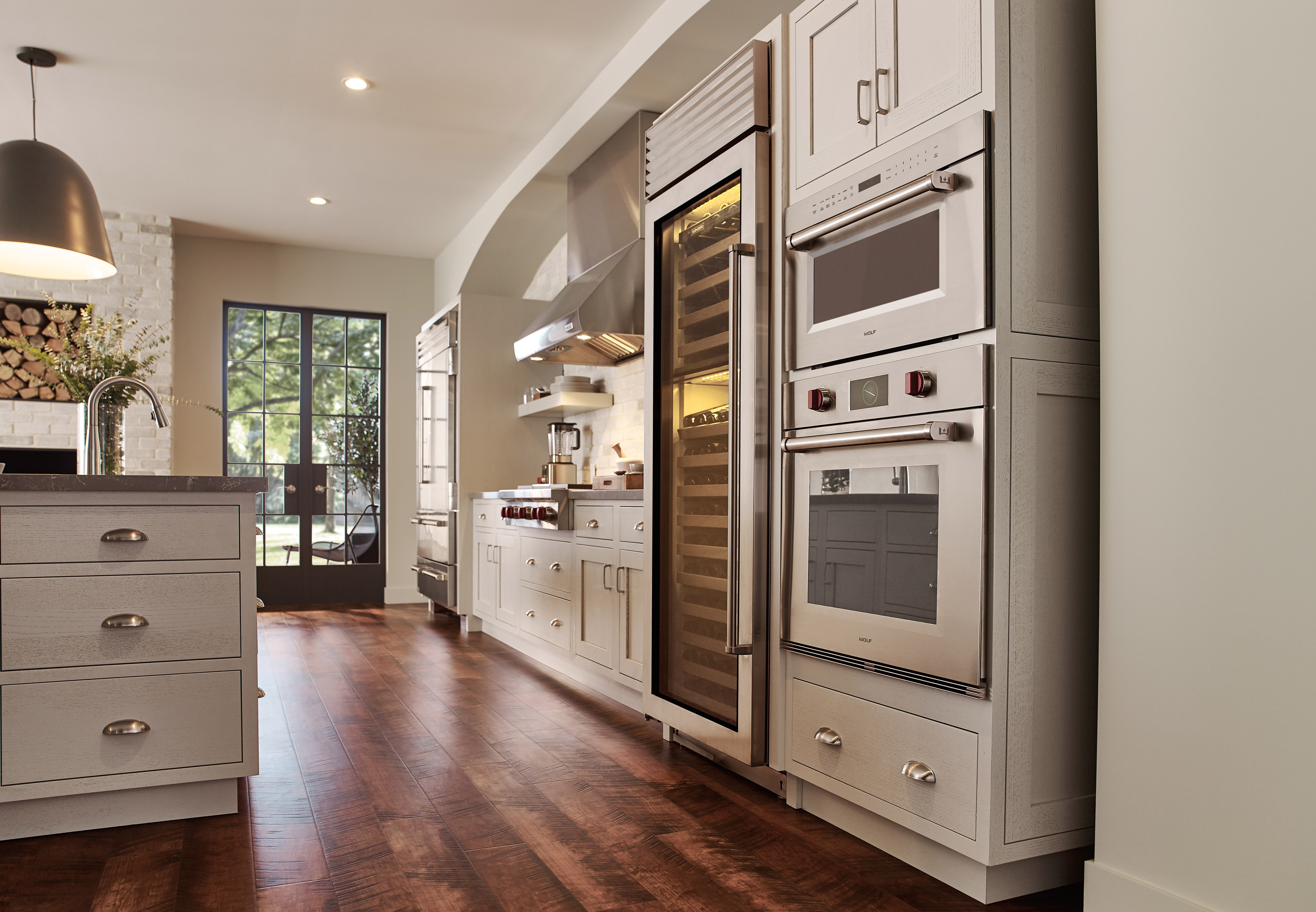 Horno microondas con puerta abatible profesional de 30" Wolf de la serie M (MDD30PM/S/PH) con un diseño clásico de piso de madera de tono medio