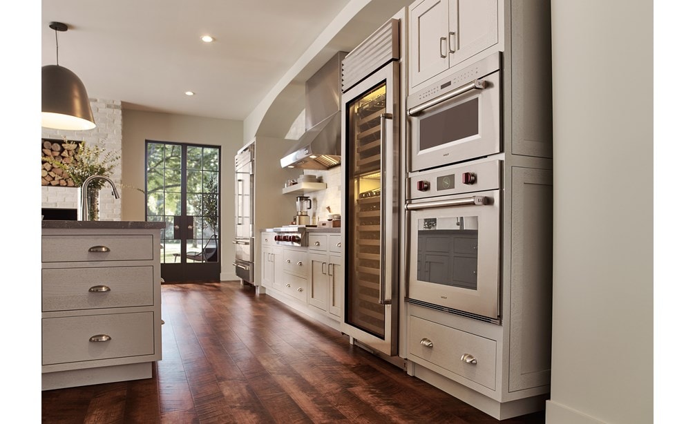 Horno microondas con puerta abatible profesional de 30" Wolf de la serie M (MDD30PM/S/PH) con un diseño clásico de piso de madera de tono medio