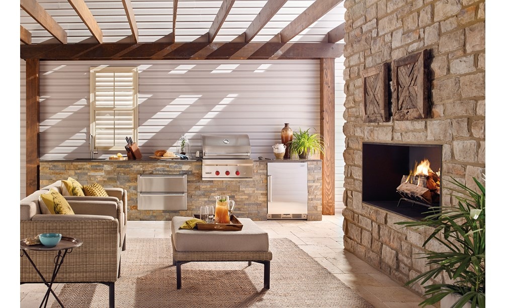 La parrilla de gas para exteriores de 30" Wolf (OG30) exhibida con el cajón calentador para exteriores de 30" Wolf (WWD30O) en un espacio de cocina al aire libre de lujo.