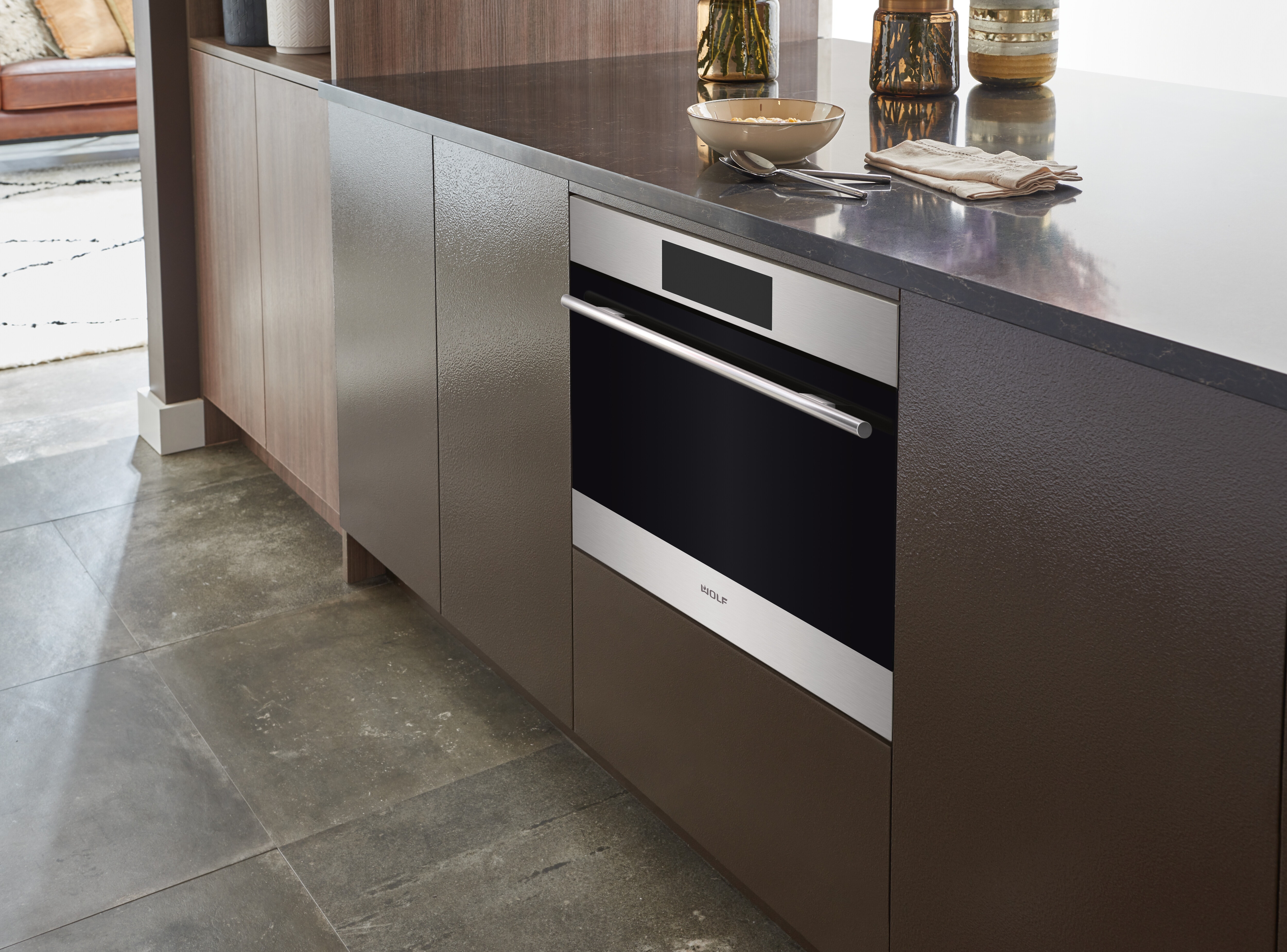 Sub-Zero, Wolf, and Cove's 24" E Series Transitional Speed Oven - SPO24TE/S/TH inside a cabinet with brown panels