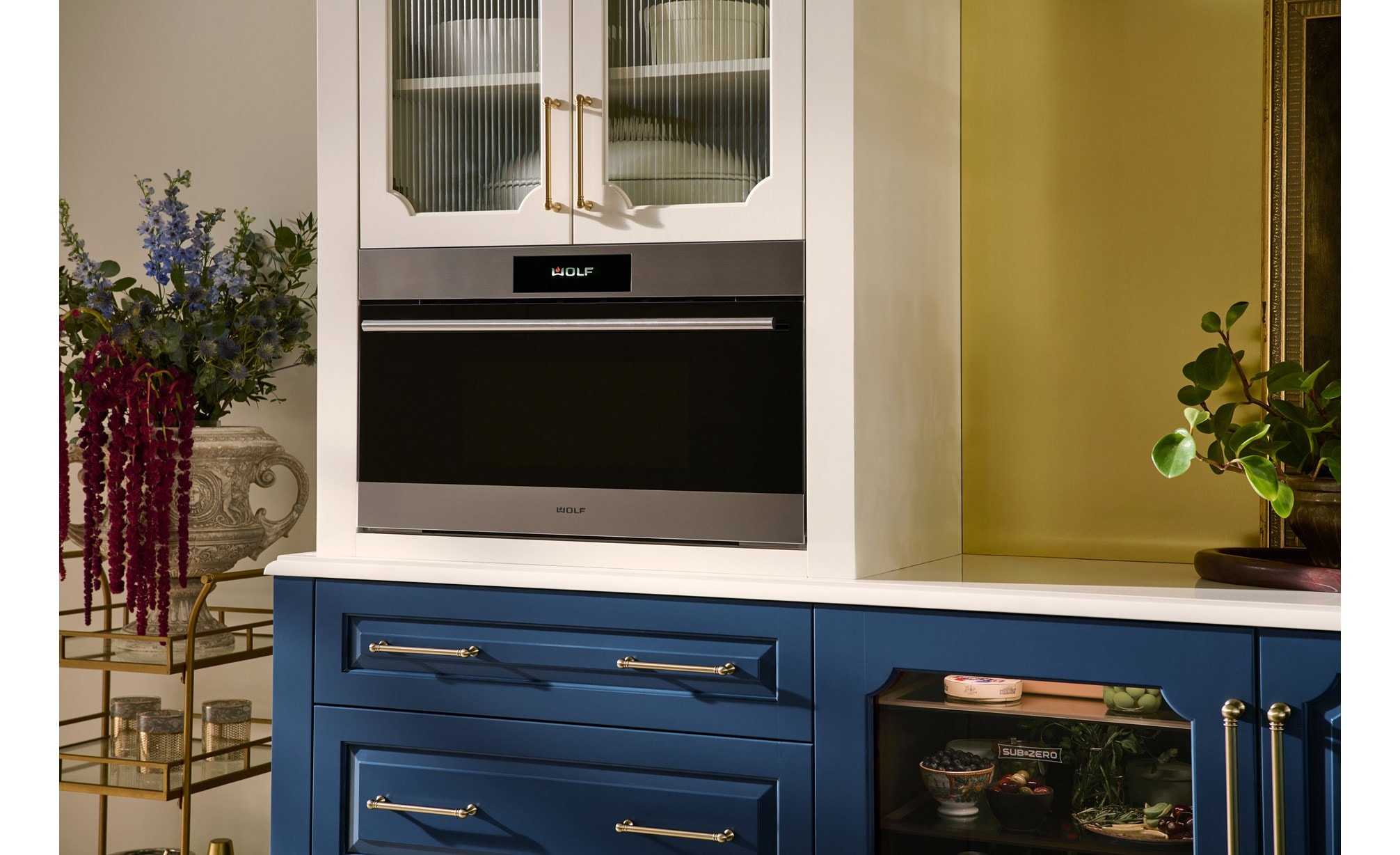 The Wolf 30" E Series Transitional Speed Oven - SPO3050TE/S/T in a modern blue and white kitchen