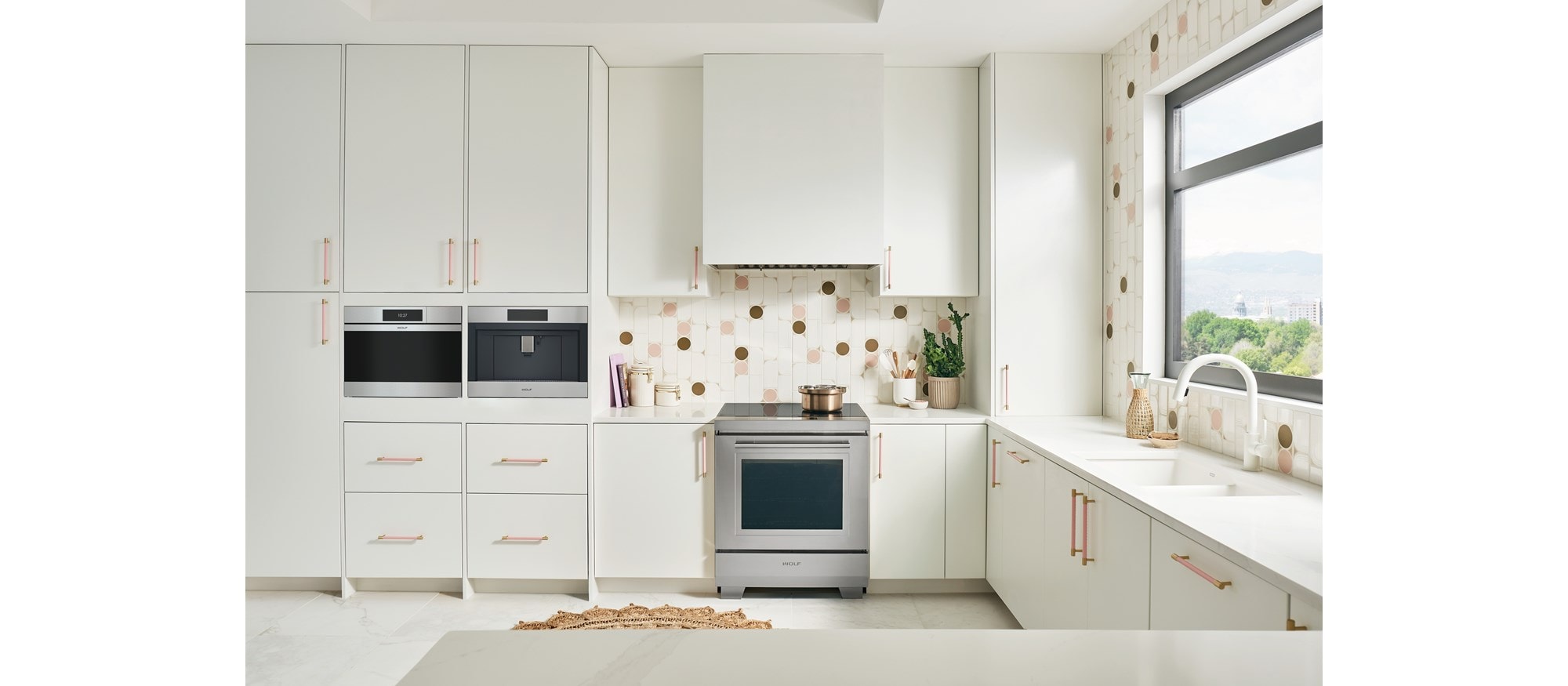 Horno de vapor contemporáneo de acero inoxidable de la serie M de 24" Wolf (CSO2450CM/S) en una pintoresca cocina blanca y rosa con vistas a la montaña