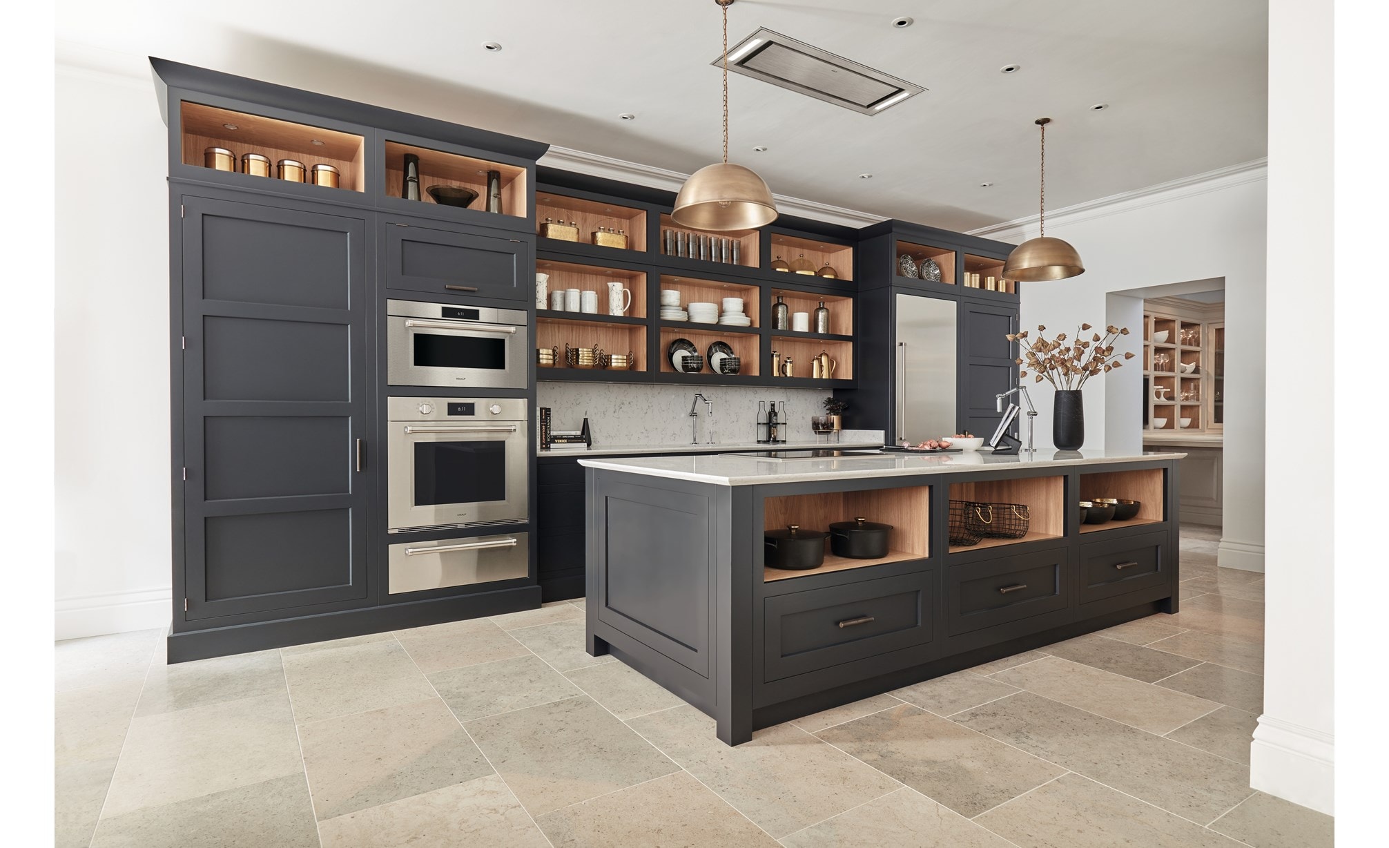 Horno de vapor con convección profesional de la serie M de 30" Wolf (CSO3050PM/S/P) instalados junto a gabinetes personalizados altos de color gris mate en cocina de baldosas de piedra