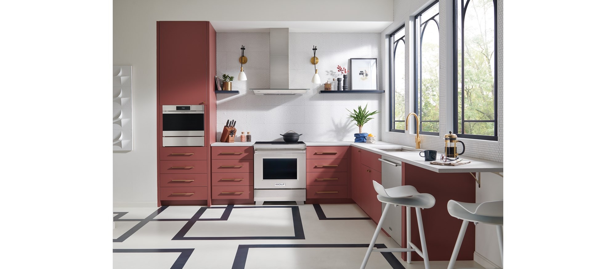 La estufa de inducción profesional de 30" y 34" Wolf (IR30450/S/P) exhibida en cocina de gabinetes de salmón con suelo geométrico.