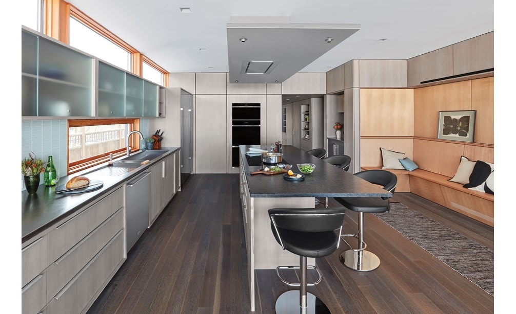 Campana extractora instalada en el techo de 36" Wolf de acero inoxidable (VC36S) exhibida combinada a la perfección sobre una gran isla de cocina en una cocina minimalista moderna