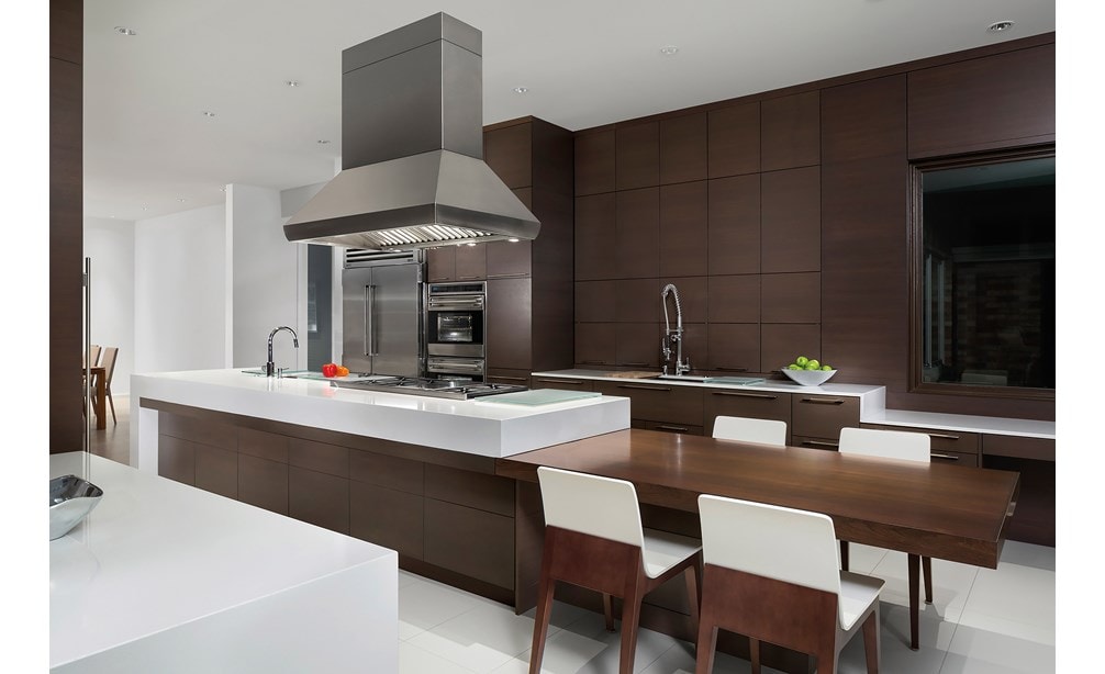 La campana extractora para islas Pro de 54" Wolf (PI543418) exhibida por encima de la estufa con quemadores sellados de 48" (SRT486G) en un gran diseño de cocina de panel ultramoderno