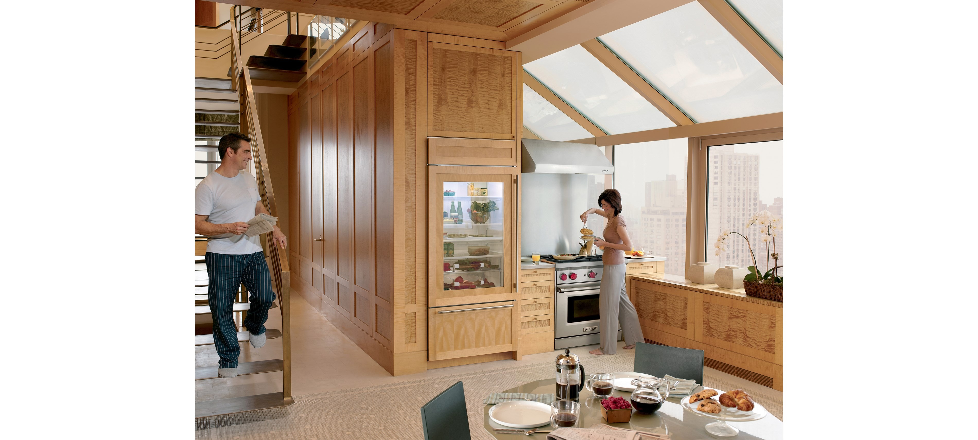 Campana extractora de pared de perfil bajo de 30" Wolf (PW302210) con un diseño de cocina personalizado con techos altos, grandes ventanas y gabinetes de madera natural