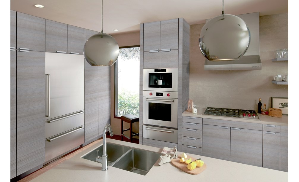 La campana extractora de pared de perfil bajo de 36" Wolf (PW362210) exhibida en un diseño de cocina moderno y limpio que utiliza gabinetes grises con detalles plateados