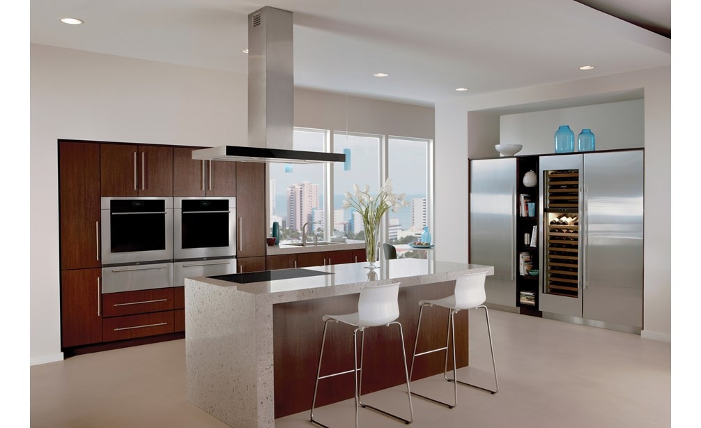 La campana extractora de placa de cocción para isla de 42" Wolf en negro (VI42B) exhibida en una cocina moderna con gabinetes de madera oscura y detalles de acero inoxidable