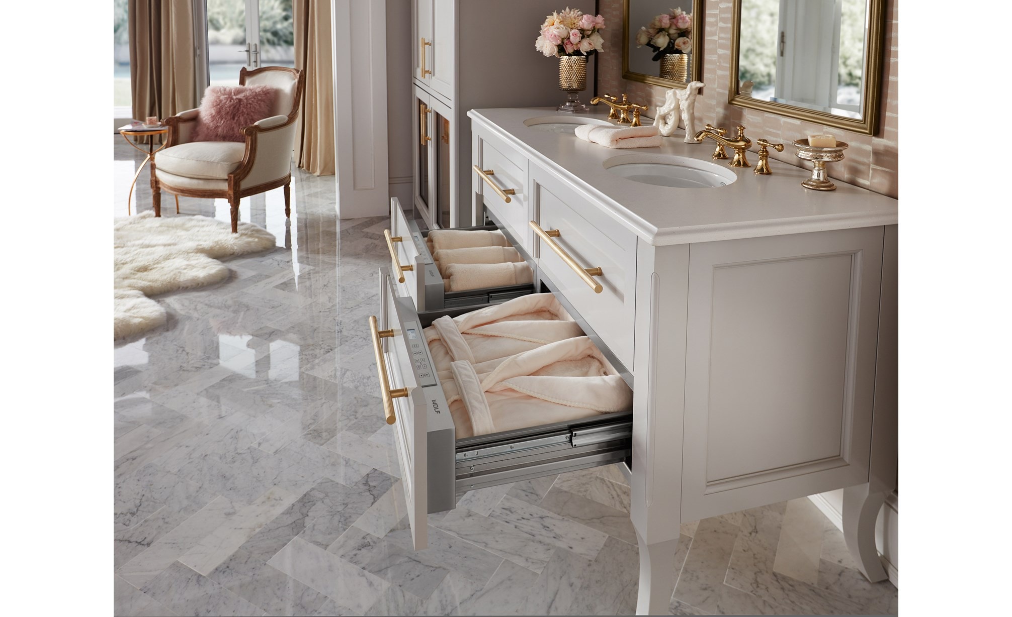 El cajón calentador de 30" Wolf (WD30) exhibido aquí manteniendo calientes las sábanas, batas y accesorios de baño en un elegante diseño de baño