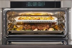 El horno de vapor con convección Wolf exhibido en una cocina de estilo mediterráneo con salpicaduras de azulejos azules y estantes de cocina abiertos.