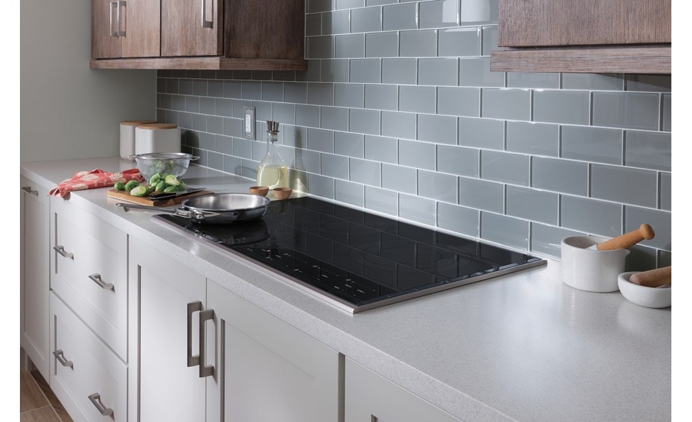 Placa de cocción de inducción Wolf instalada en un mostrador de cocina blanco.