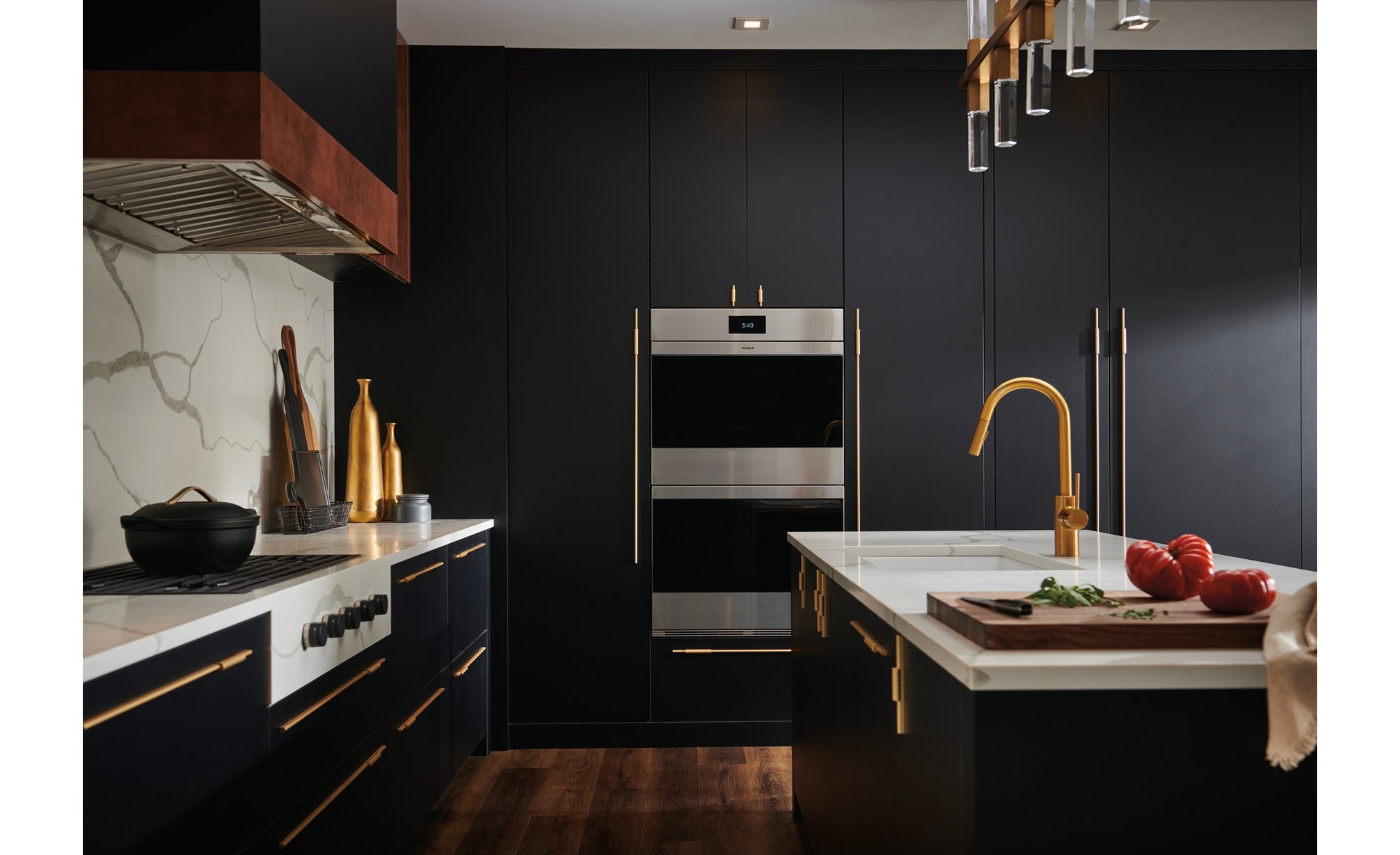 Wolf M Series Ovens and Wolf Contemporary Gas Cooktop shown in upscale luxury kitchen featuring seamless dark blue cabinetry