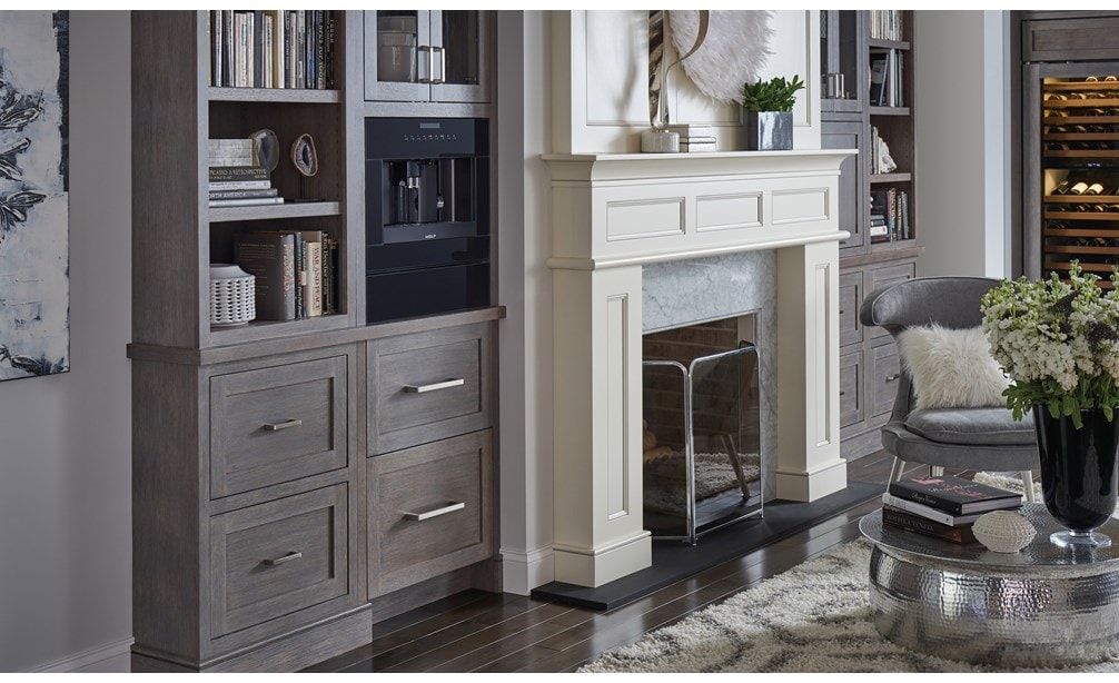 El sistema para café de vidrio negro de 24" Wolf (EC24/B) exhibido colocado a la perfección en una estantería con tonos cálidos de madera y manijas modernas