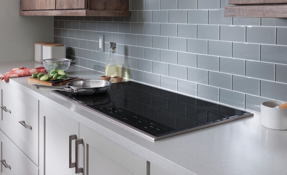 Placa de cocción de inducción Wolf instalada en un mostrador de cocina blanco.