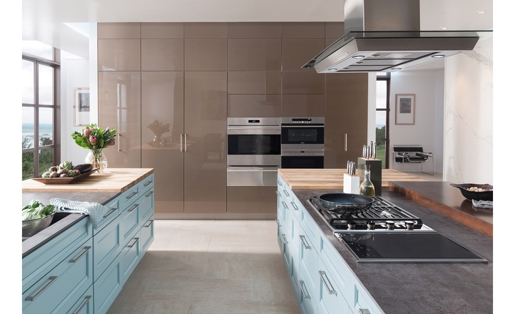 La placa de inducción de transición de 15" Wolf (CI152TF/S) exhibida con la campana extractora de isla de 45" Wolf (VI45G) en una gran cocina abierta