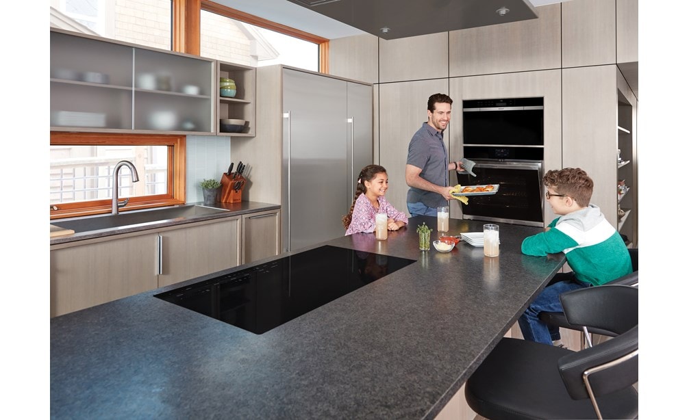 La placa de inducción contemporánea de 36" Wolf (CI365C/B) exhibida en la isla de cocina extragrande es altamente eficiente y excepcionalmente segura