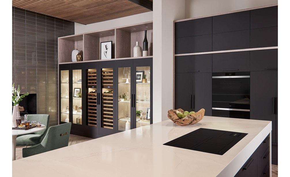 La placa de inducción contemporánea Wolf 36" (CI36560C/B) presenta un diseño conceptual de cocina abierta con una gran isla de cocina blanca y gabinetes de cocina negros.